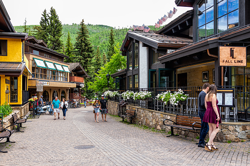 Vail, USA - June 29, 2019: Vacation town in rocky mountains of Colorado with people walking by shops stores and restaurants on cobblestone of Gore Creek drive