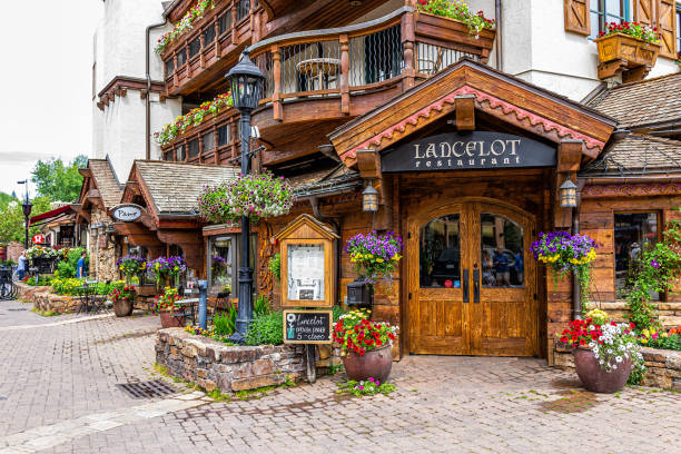 Swiss style resort town in rocky mountains of Colorado with Lancelot restaurant sign entrance by shops on Gore Creek drive Vail, USA - June 29, 2019: Swiss style resort town in rocky mountains of Colorado with Lancelot restaurant sign entrance by shops on Gore Creek drive arthurian legend stock pictures, royalty-free photos & images