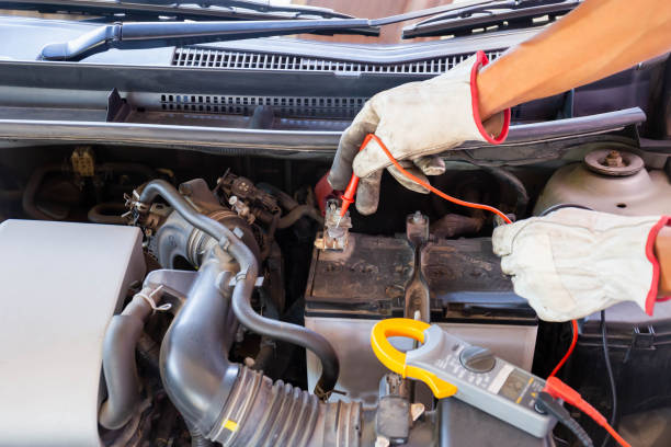 istock Auto mechanic working on car engine checking battery in mechanics garage, Repair and Maintenance service 1406112039