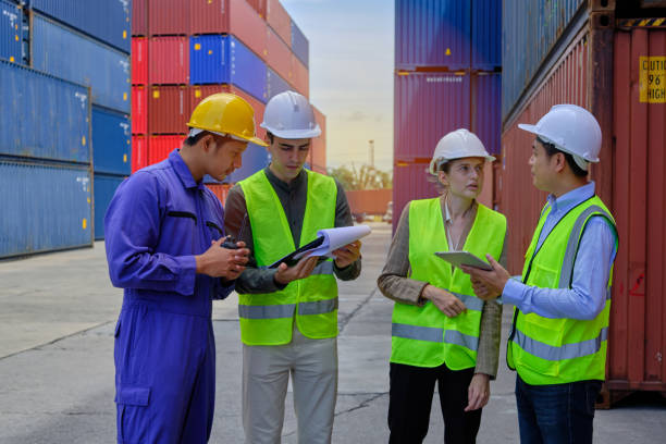 istock Group of workers teamwork at logistics terminal with many stacks of containers. 1406115636