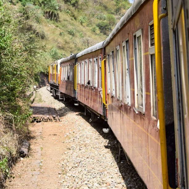istock Toy Train moving on mountain slopes, beautiful view, one side mountain, one side valley moving on railway to the hill, among green natural forest. Toy train from Kalka to Shimla in India 1406118544