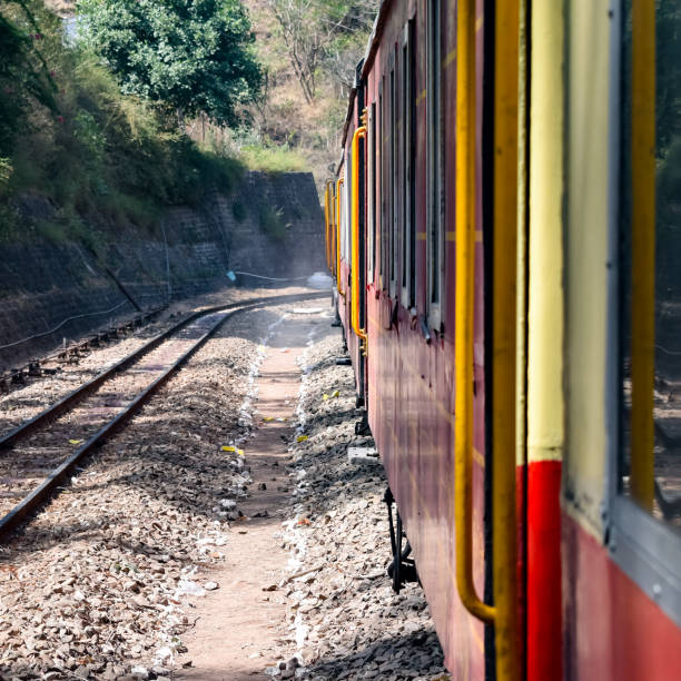 istock Toy Train moving on mountain slopes, beautiful view, one side mountain, one side valley moving on railway to the hill, among green natural forest. Toy train from Kalka to Shimla in India 1406118559