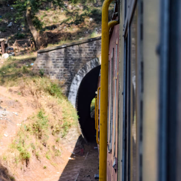 istock Toy Train moving on mountain slopes, beautiful view, one side mountain, one side valley moving on railway to the hill, among green natural forest. Toy train from Kalka to Shimla in India 1406118578
