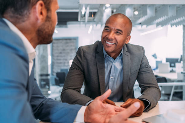 Business partners in meeting. Shot of two colleagues having a discussion in the board room. Confident business people working together in the office. Corporate business persons discussing new project and sharing ideas in the workplace. business consultation stock pictures, royalty-free photos & images