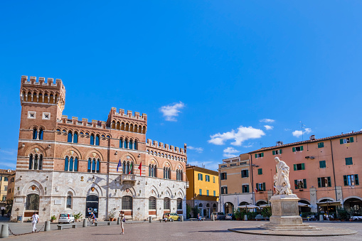 Tourists visiting Piazza Dante in Grosseto, home to the Palazzo Aldobrandeschi (seat of the Province of Grosseto). At the centre stands the statue of Leopold II of Tuscany, sculpted by artist Luigi Magi in 1846.