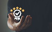 The hand of businessmen shows the sign of the top service Quality assurance, Guarantee, Standards, ISO certification and standardization concept, customer satisfaction, and service experience.