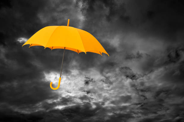 Flying blue umbrella and cloudy rainy sky closeup. Weather forecast concept