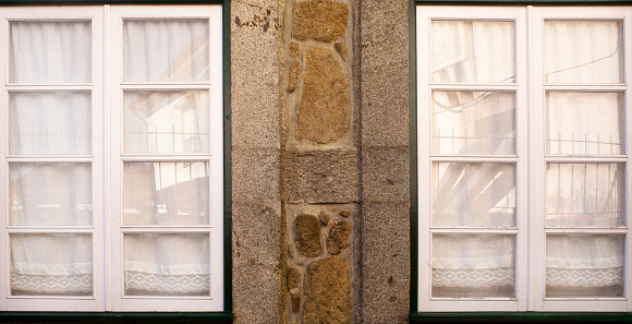 Traditional facade in old town Valença do Minho, Minho, northern Portugal. Two windows, stone wall.