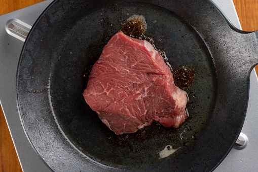 Bake beef steak in an iron skillet.
