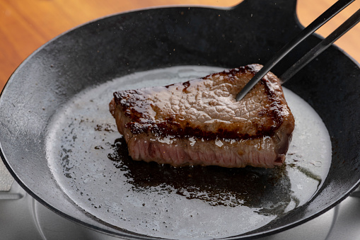 Bake beef steak in an iron skillet.
