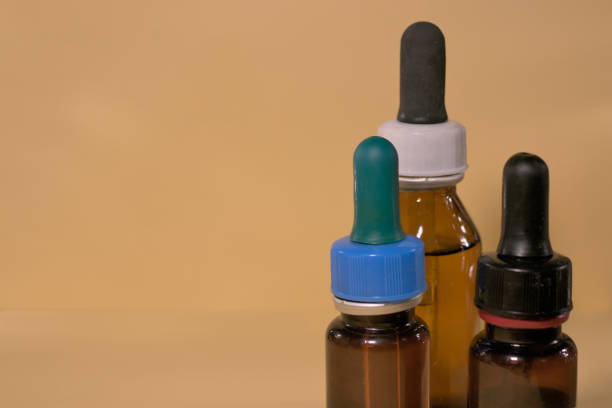 istock Brown bottles with droppers, no branding, text space, yellowish background. 1406138235