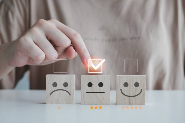 istock Customer service rating experience and feedback emotion and satisfaction survey with star and negative, neutral and positive facial expressions. hand choose 3 star neutral face icon on wood cube. 1406139182