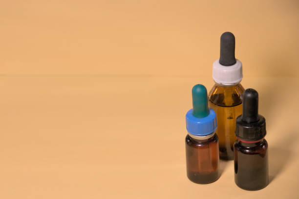 istock Brown bottles with droppers, no branding, text space, yellowish background. 1406139744