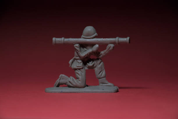 istock Miniature toy soldier with weapon in hand, reddish background 1406143824