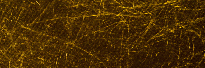 Line textures on fabric in gold color. Glittering fabric panoramic background. High resolution texture for graphic work