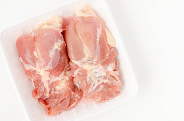 Raw Chicken thighs meat on foam tray on white background