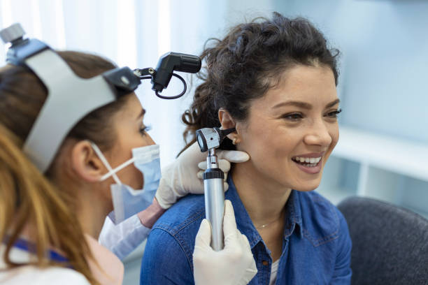 проверка слуха. врач-отоларинголог проверяет ухо женщины с помощью отоскопа или аурископа в медицинской клинике. - ear canal стоковые фото и изображения
