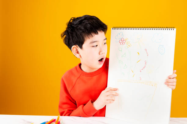 Smiling boy sitting and writing homework