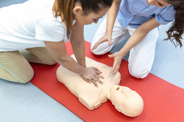 istock CPR class with instructors talking and demonstrating firt aid, compressions ans reanimation procedure. Cpr dummy 1406151299