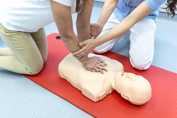 istock CPR class with instructors talking and demonstrating firt aid, compressions ans reanimation procedure. Cpr dummy 1406151370