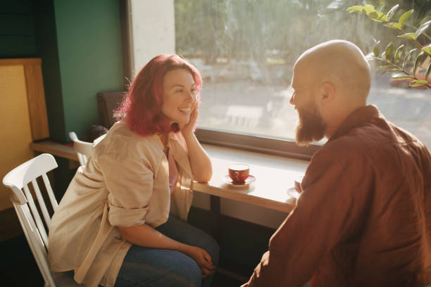 istock Happy couple having conversation while drinking coffee in cozy coffeehouse. 1406152041
