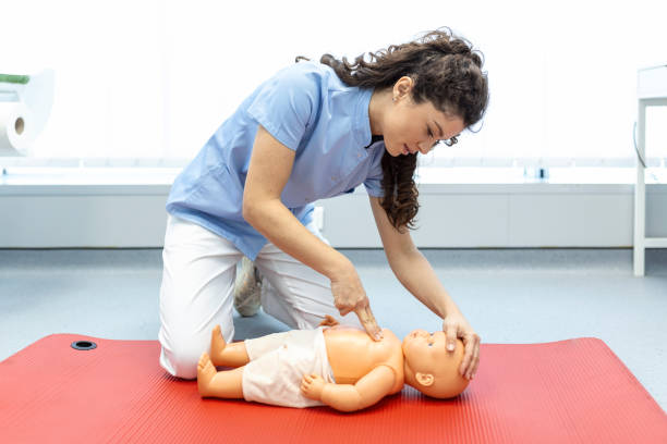 istock Woman performing CPR on baby training doll with one hand compression. First Aid Training - Cardiopulmonary resuscitation. First aid course on cpr dummy. 1406152089