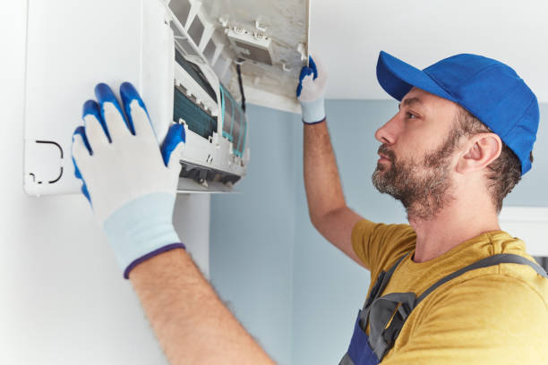 istock Repairman cleaning and fixing indoors AC unit. 1406152614