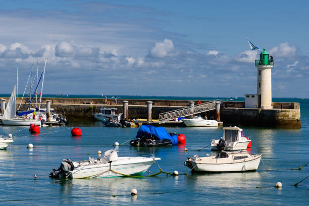 View on Phare de la Flotte View on the Phare de la Flotte and some boats on the sea from the beach plage de l' Arnérault on a sunny summerday flotte stock pictures, royalty-free photos & images