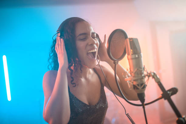 istock Charming Hispanic Young Woman Singing in Recording Studio 1406155677