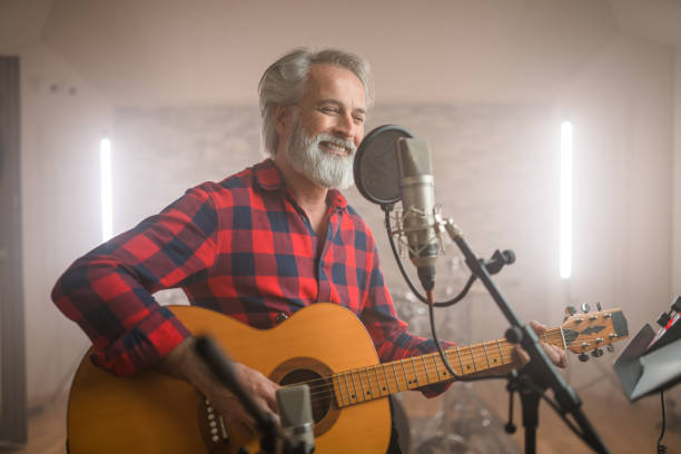 istock Senior Caucasian Guitarist Playing Classical Guitar in Recording Studio 1406155703