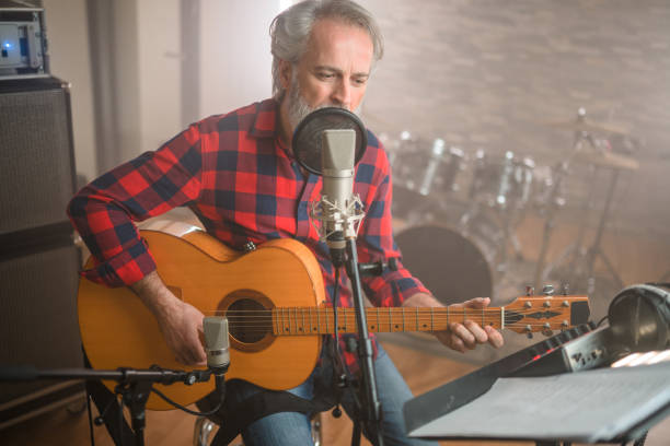istock Senior Caucasian Guitarist Playing Classical Guitar in Recording Studio 1406155712
