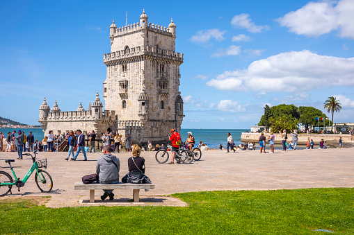 Lissabon, Portugal - May 24, 2022: View of Torre de Belém in summer day in the sunshine with tourists.