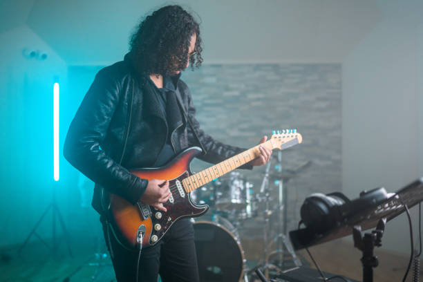 istock Hispanic Guitarist Recording Music in Recording Studio 1406156119