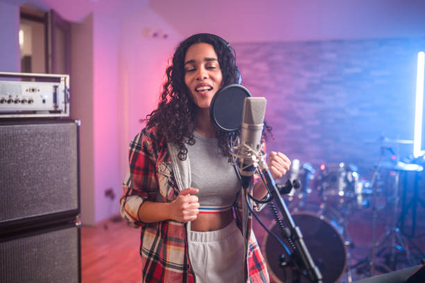 istock Young Hispanic Beautiful Woman With Eyes Closed Singing in Recording Studio 1406156419