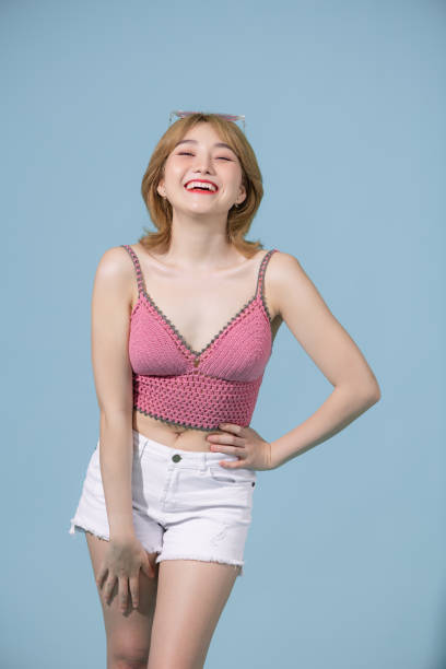 istock Sexy carefree woman posing near blue wall in studio. 1406156607