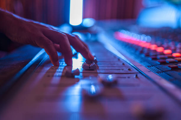 Shot of man's hand operating with sound recording studio mixer.
