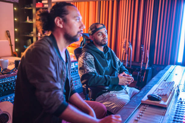 istock Two Male Musicians Operating With Sound Recording Studio Mixer 1406156711