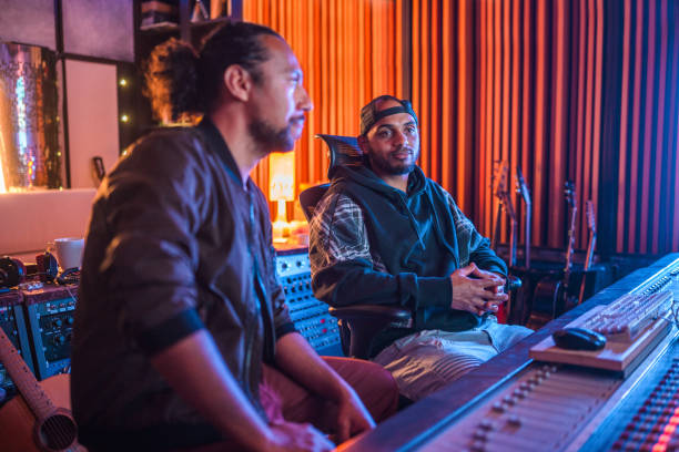 istock Two Male Musicians Operating With Sound Recording Studio Mixer 1406156735