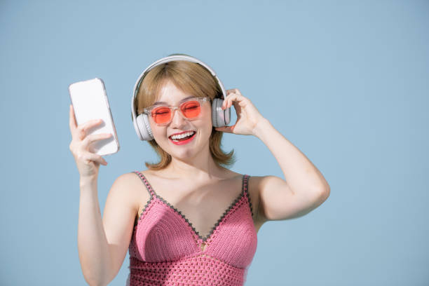 hermosa mujer escuchando música a través de una aplicación en su teléfono. - samba dancing audio fotografías e imágenes de stock