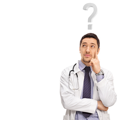Young pensive doctor in a white coat thinking with a question mark over his head isolated on white background