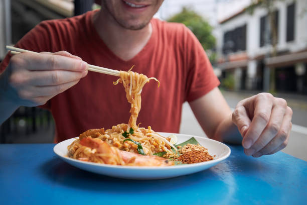 close-up of chopsticks with pad thai food - gourmet enjoyment food freshness imagens e fotografias de stock