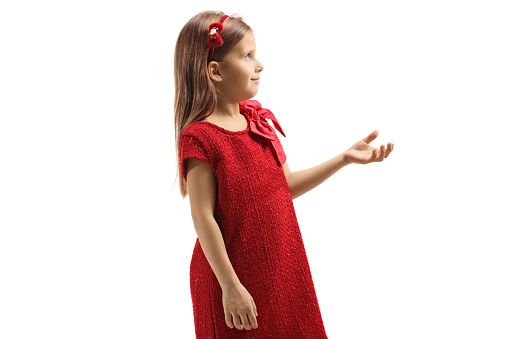 Profile shot of a little girl in a red dress holding her hand front and waiting isolated on white background
