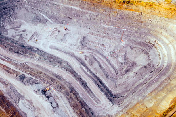 istock Top view of an iron ore quarry. Excavator loading ore into train cars. Environmental pollution problems. 1406166929