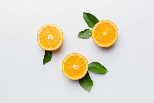 Fruit pattern of fresh orange slices on colored background. Top view. Copy Space. creative summer concept. Half of citrus in minimal flat lay stock photo