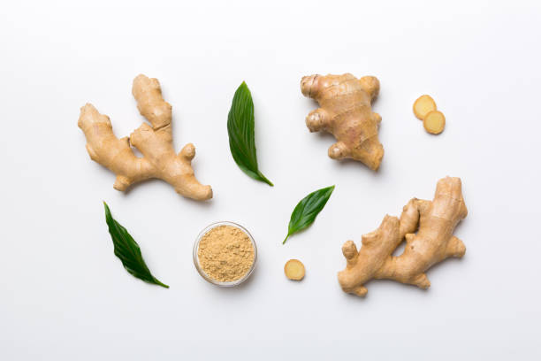 Finely dry Ginger powder in bowl with green leaves isolated on colored background. top view flat lay Finely dry Ginger powder in bowl with green leaves isolated on colored background. top view flat lay. finely stock pictures, royalty-free photos & images