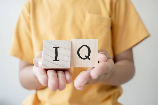 istock Kid hands holding wooden blocks with alphabet IQ intelligence quotient 1406171734