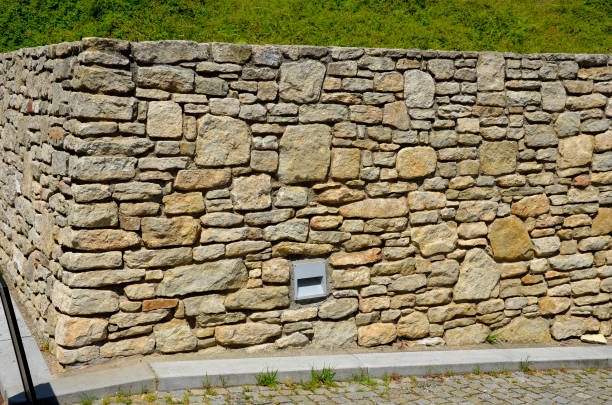 istock beautifully folded retaining wall with a granite attic with small joints. brown beige yellow irregular gneiss stone holding a slope above it. there are undemanding perennials around 1406177020