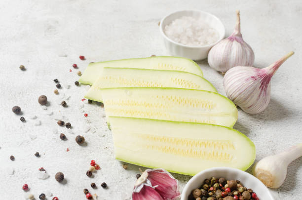 Slices of  fresh vegetable marrow garlic and spices for cooking on light background. Vegetarian organic vegetables.Healthy food.Copy space.Place for text
