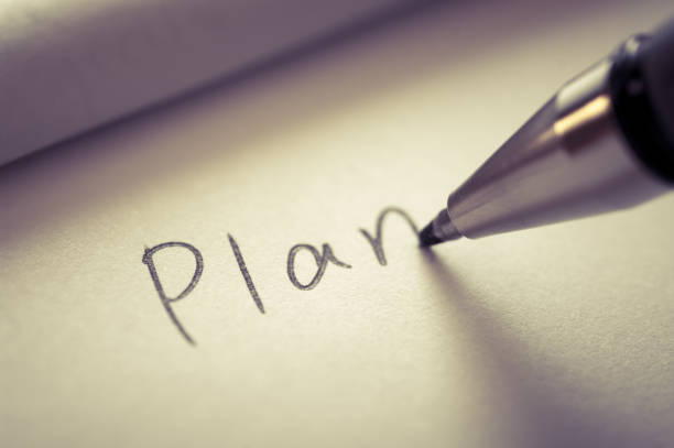 istock Close up image of writing a word PLAN on a notebook paper. 1406177656