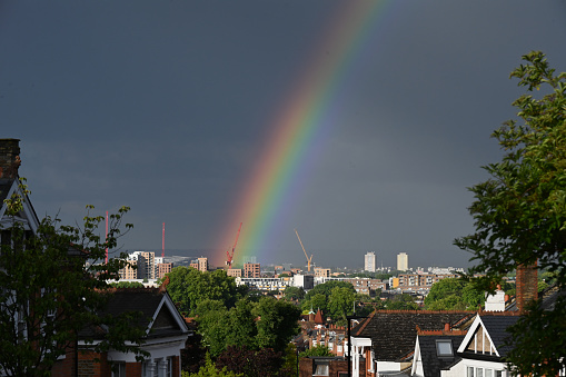 Rainbow over  suburban rooftops in North  London, UK